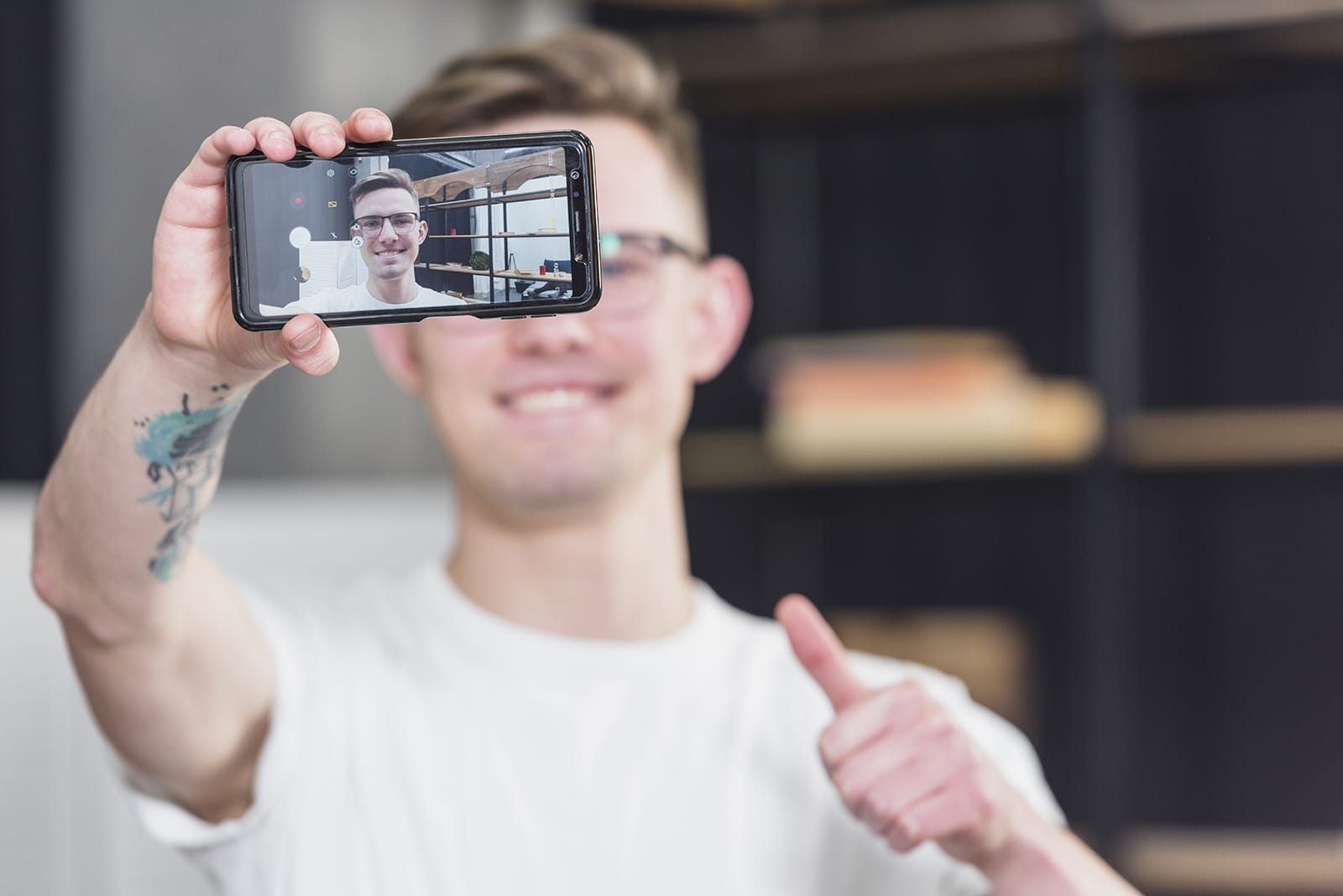 Парень позирует на камеру смартфона